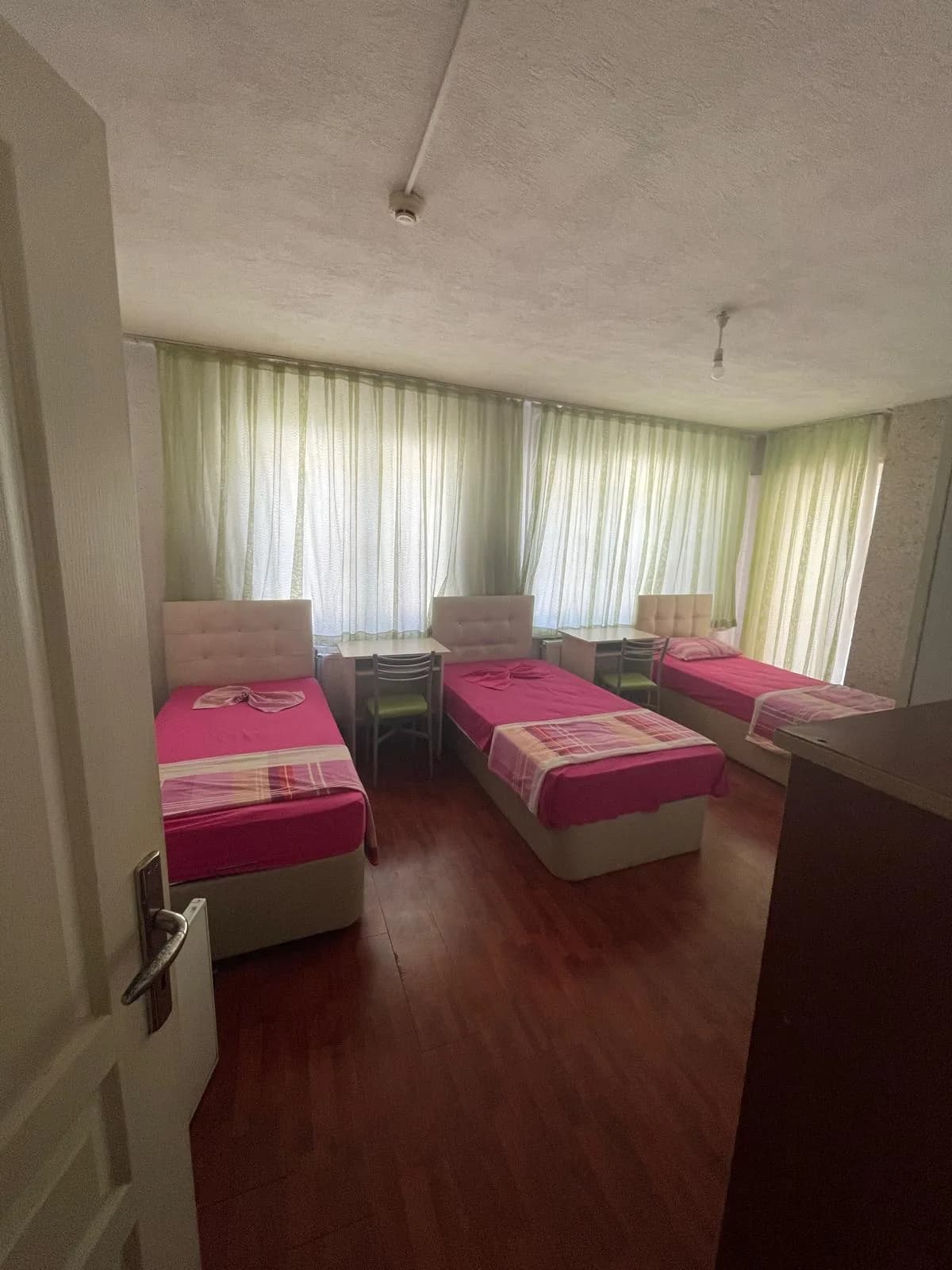 Elit Kız Öğrenci Yurdu'nda üç yatak ve çalışma masaları bulunan üç kişilik oda